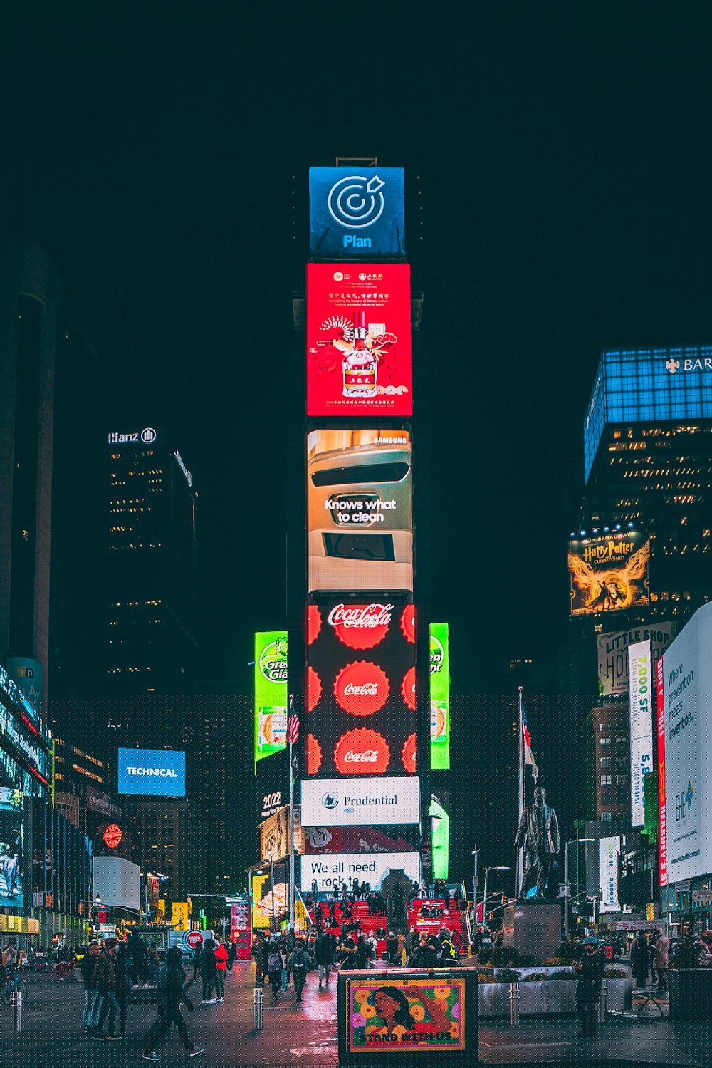 Digital billboard tower lighting up a city square at night